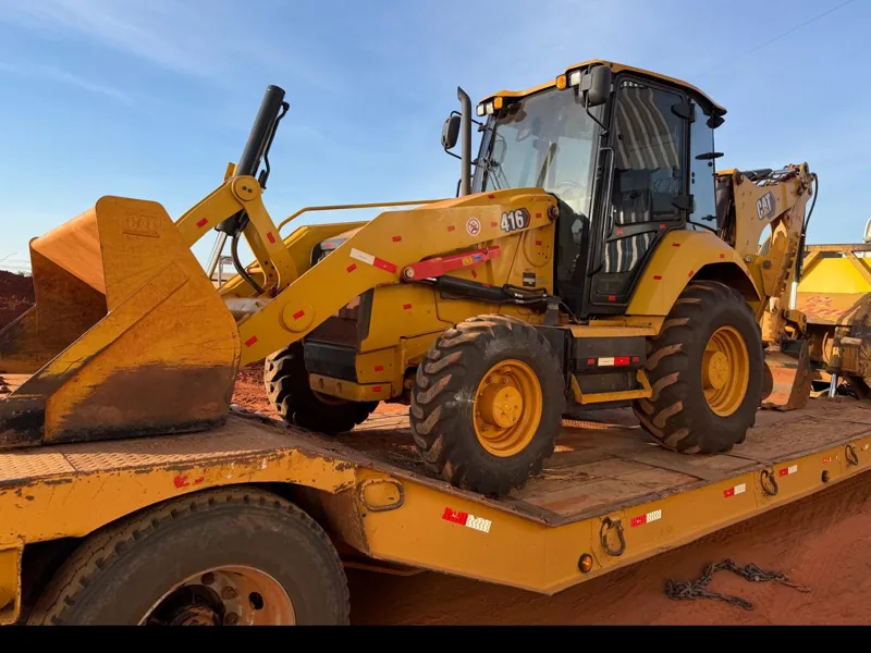 Retroescavadeira Caterpillar 416 da frota da Bergo sobre prancha de transporte